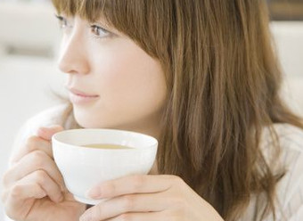 体に優しいイヌリンのサプリメントを混ぜたコーヒーを飲む女性